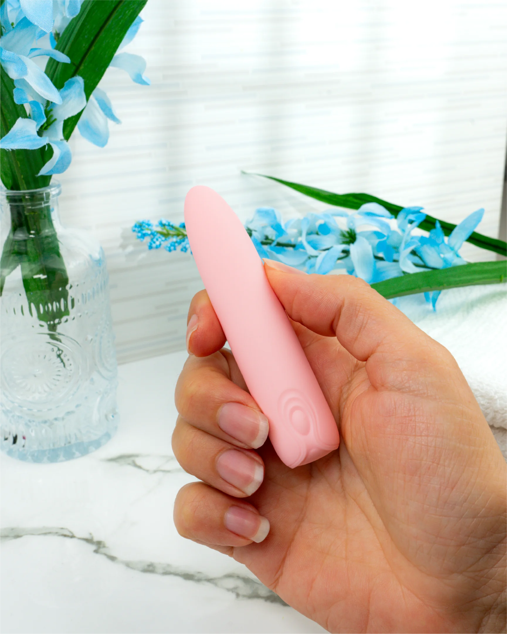 Hand holding Blush & Bloom Hyacinth pink bullet vibrator showing compact size, ergonomic grip, and easy one-button control
