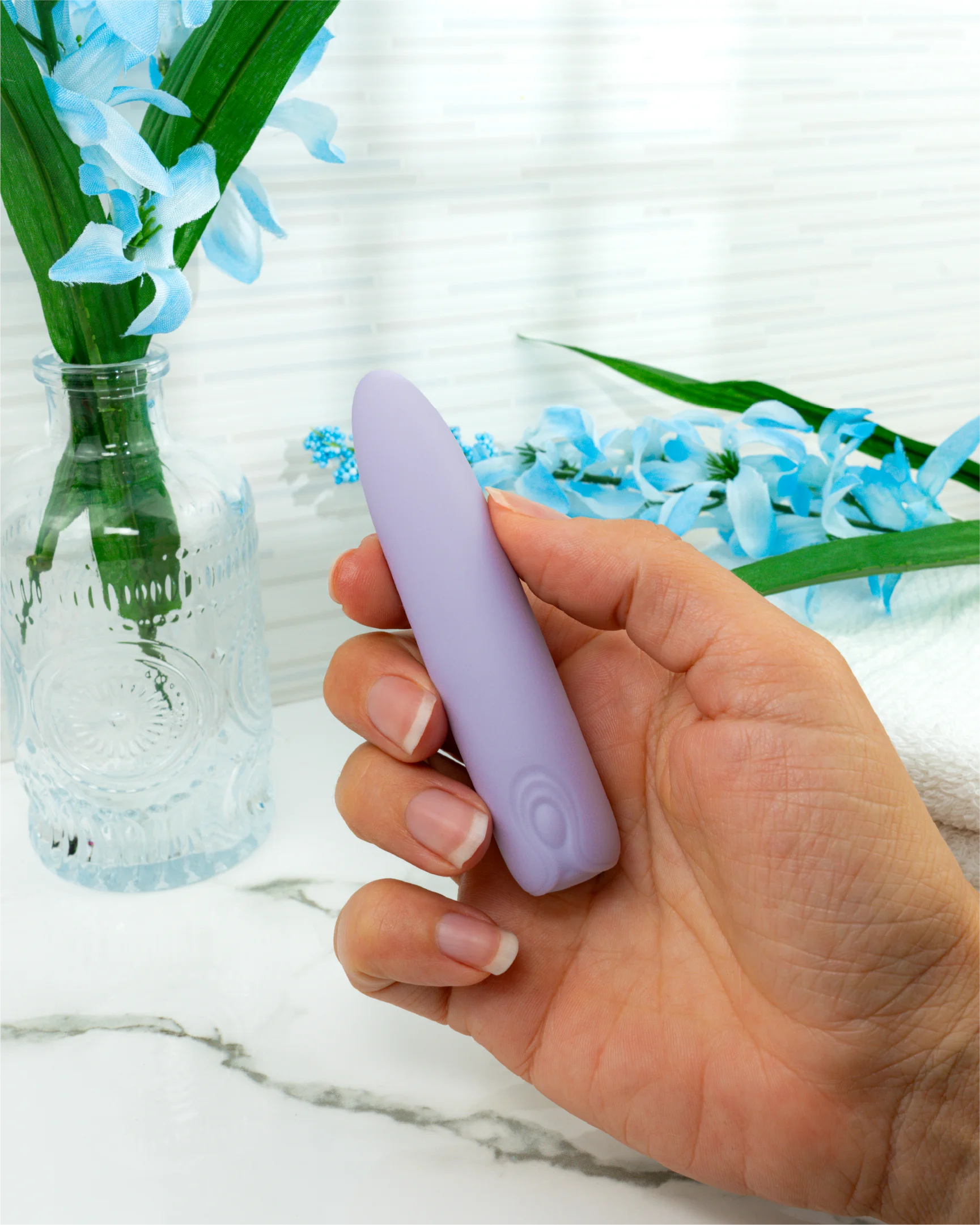 Hand holding pastel purple Hyacinth bullet vibrator showing compact size and easy grip for controlled clitoral stimulation