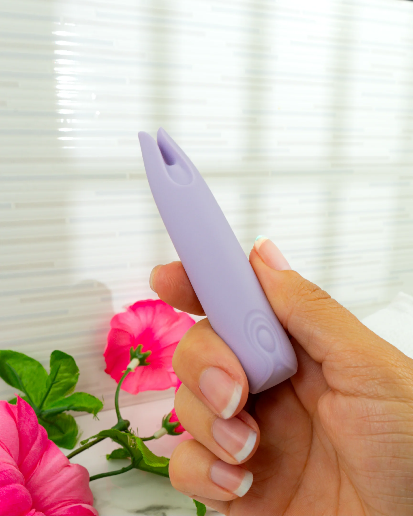 Hand holding Blush & Bloom Petunia pastel purple dual-tip clitoral vibrator showing compact size and ergonomic grip