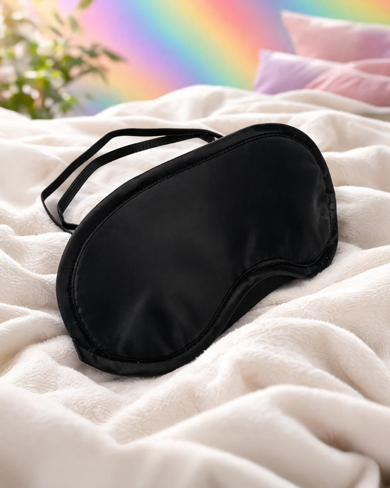 Black satin blindfold on bed with smooth soft fabric designed for comfortable sensory play and gentle vision blocking
