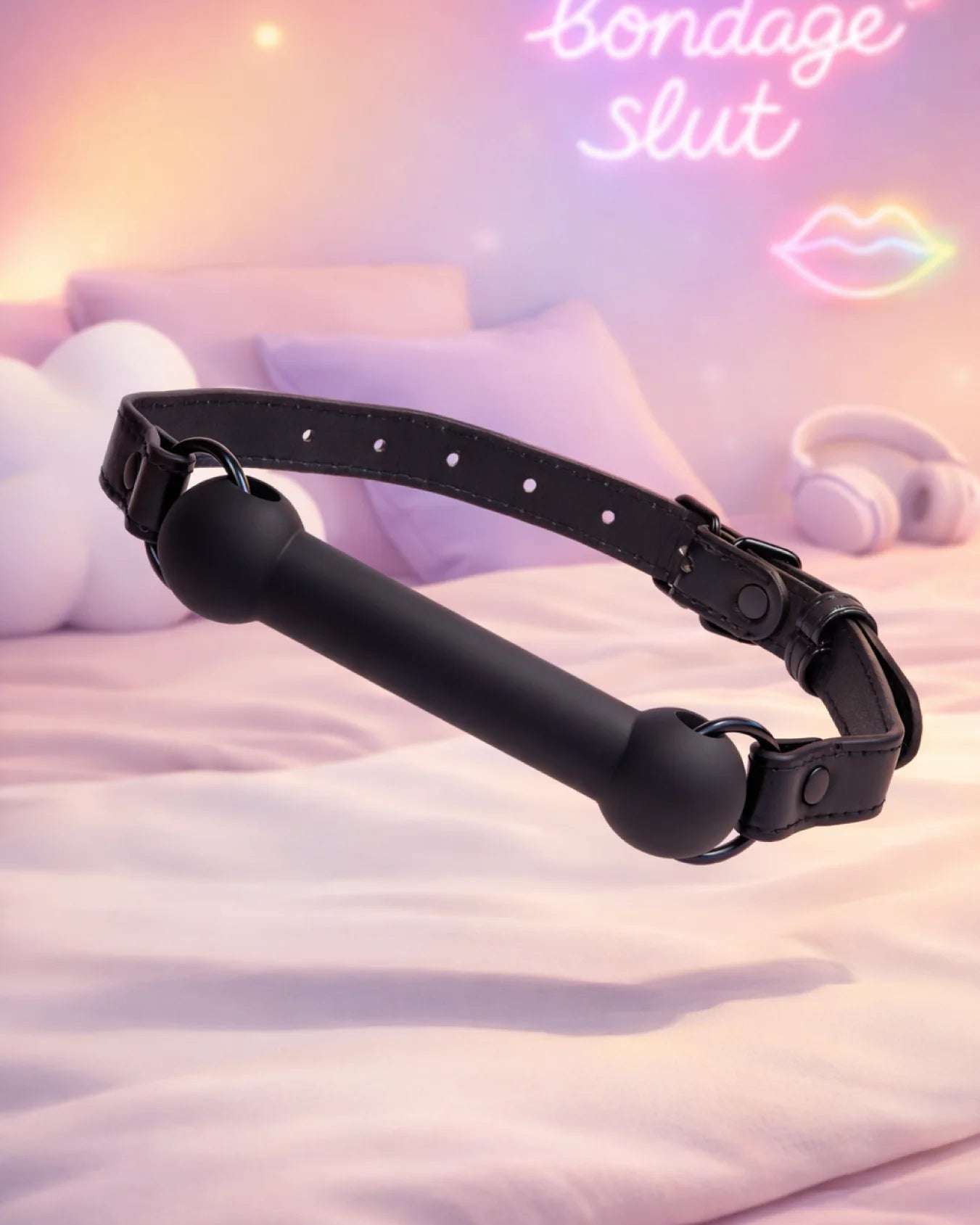 Black silicone bit gag by Empower Play™ floating in a bedroom scene, sleek and beginner-friendly mouth restraint