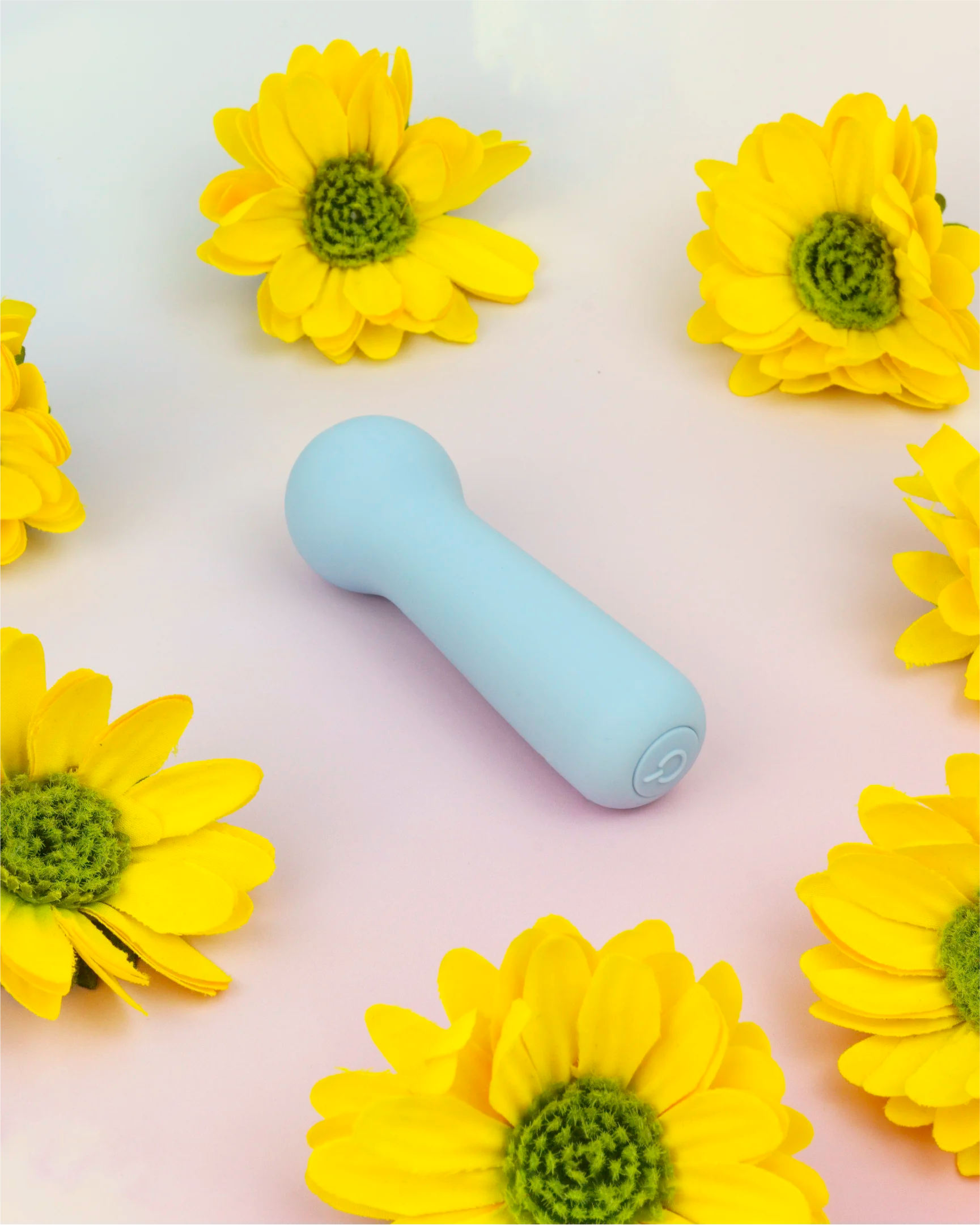 Pastel blue Joy Penny mini wand vibrator in clean flat lay with floral background, compact wand-style design for targeted stimulation