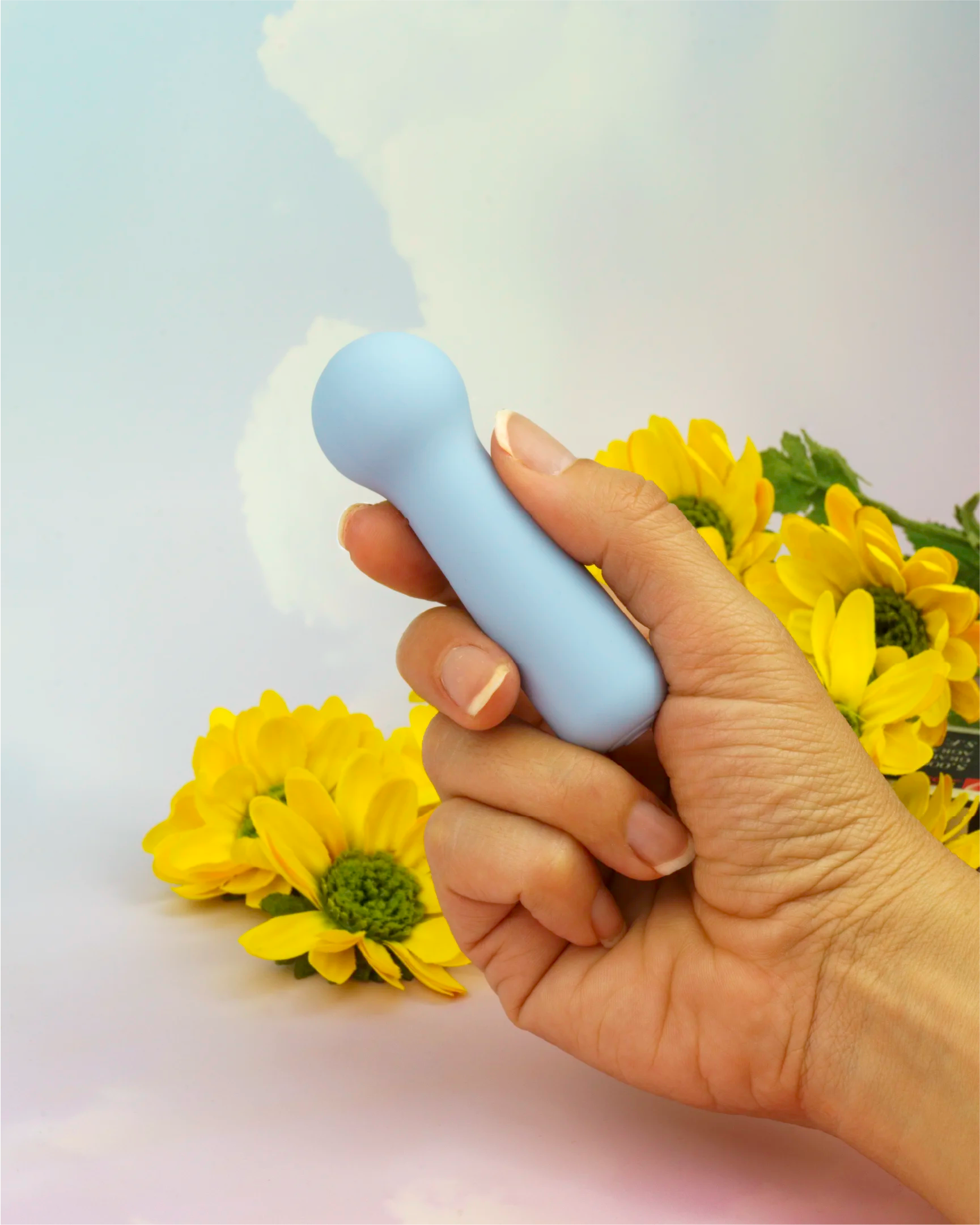 Pastel blue Joy Penny mini wand vibrator held in hand showing small discreet size, travel-friendly design with smooth silicone finish