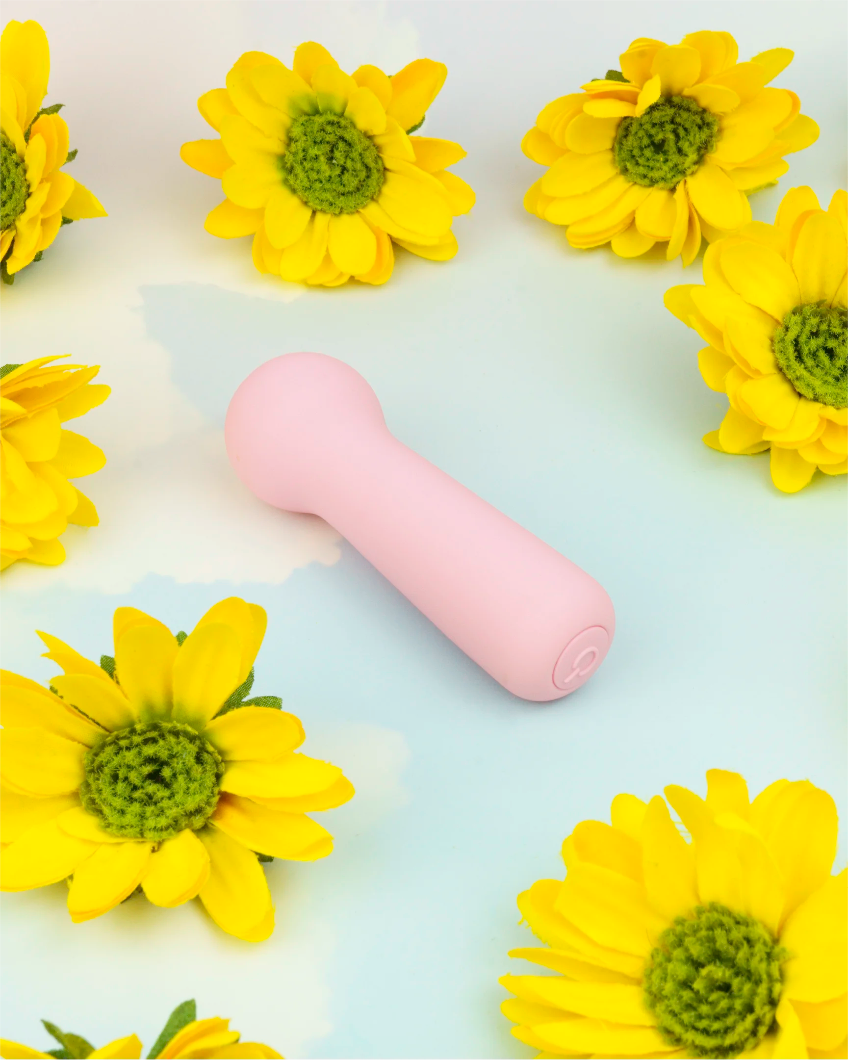 Pastel pink Joy Penny rechargeable mini wand vibrator in clean flat lay with flowers, compact shape designed for precise wand-style stimulation