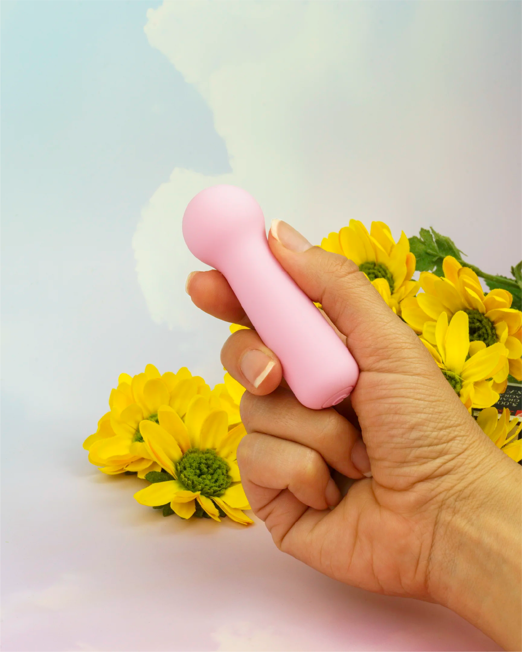 Hand holding pastel pink Joy Penny mini wand vibrator showing small ergonomic size, discreet design with smooth silicone and rounded stimulation head