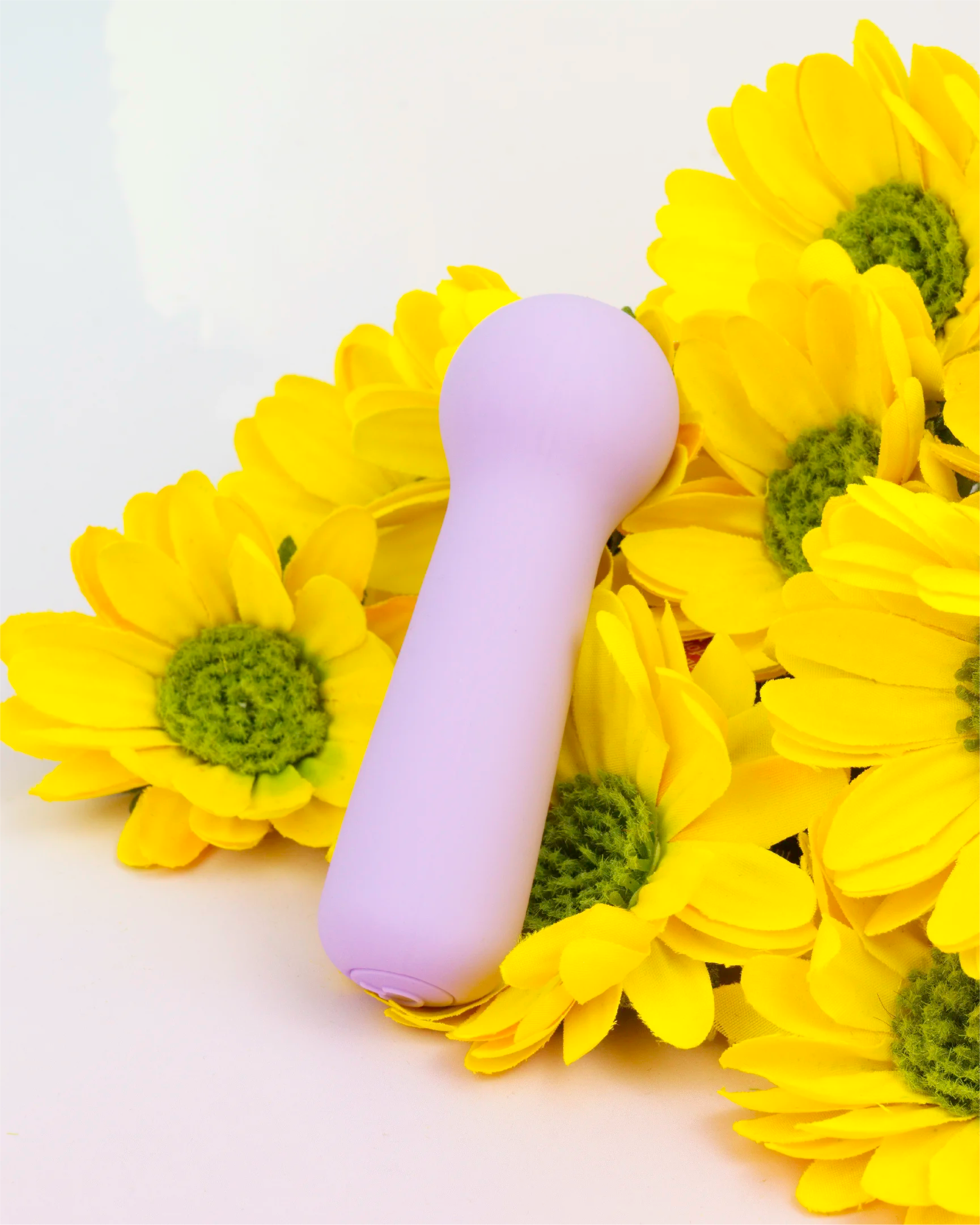 Pastel purple Joy Penny mini wand vibrator with rounded head styled with bright flowers, compact waterproof design made with body-safe silicone