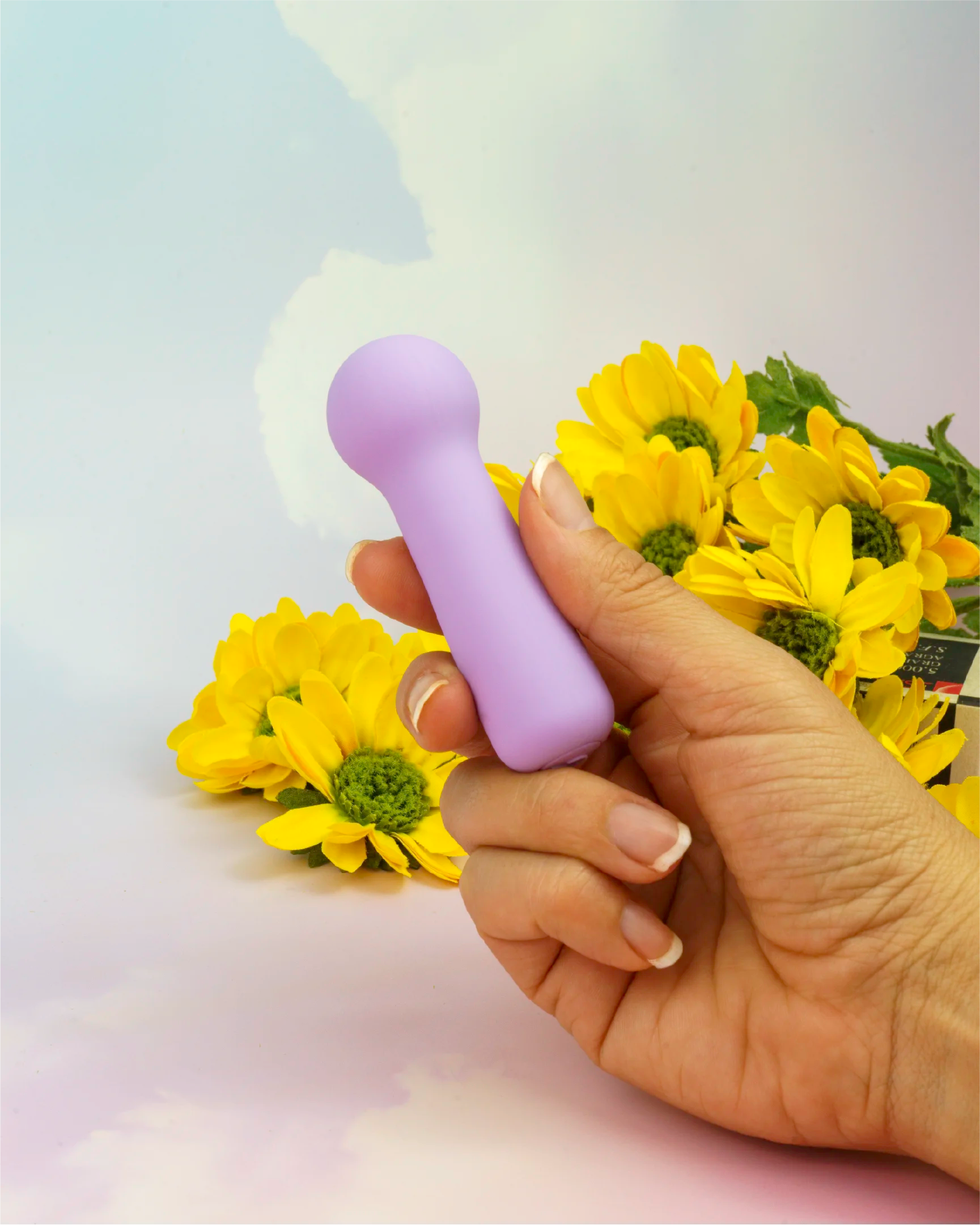 Pastel purple Joy Penny mini wand vibrator held in hand to show compact size, ergonomic grip and smooth silicone wand head design