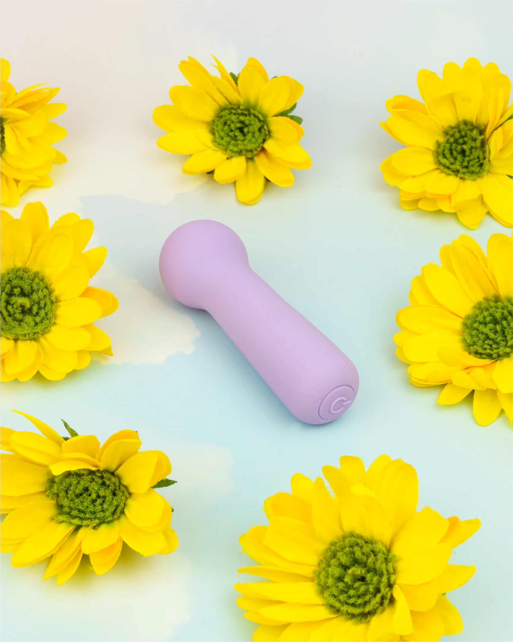 Pastel purple Joy Penny mini wand vibrator in minimal flat lay with floral accents, designed for focused stimulation and everyday comfort