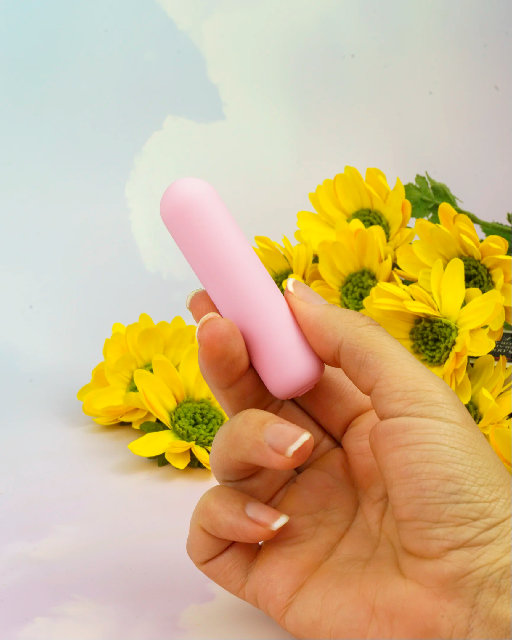 Hand holding pastel pink Joy Pippa mini bullet vibrator showing compact size, discreet travel-friendly design with smooth silicone finish