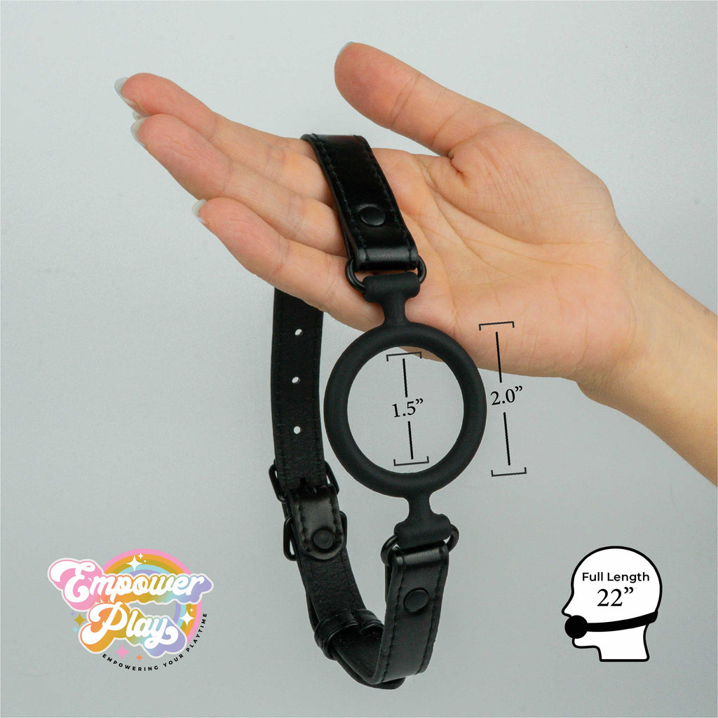Midnight black silicone O-ring gag shown in hand with size measurements for breathable open-mouth fit