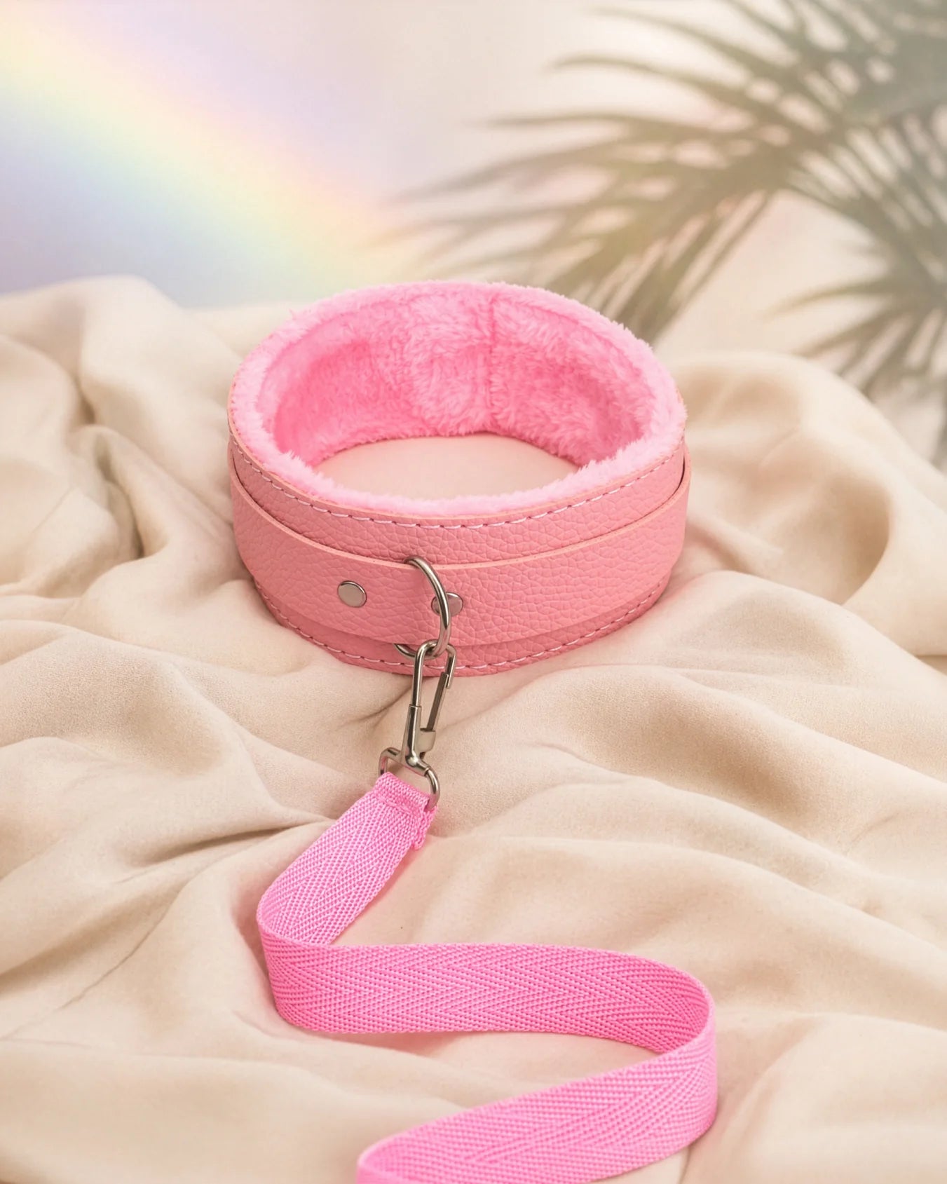 Pink bondage collar and leash resting on soft bed sheets, beginner-friendly BDSM collar designed for comfort and gentle control