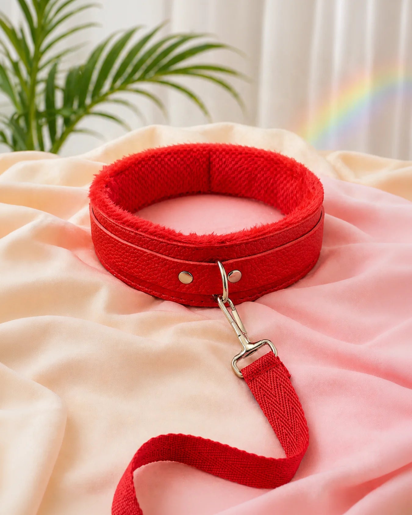 Red bondage collar and leash resting on soft sheets, beginner-friendly restraint collar with secure adjustable fit