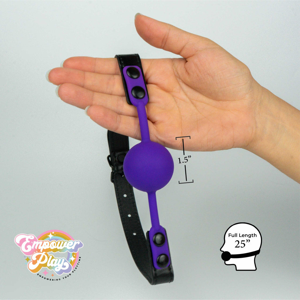 Royal purple silicone ball gag shown in hand with 1.5 inch ball size